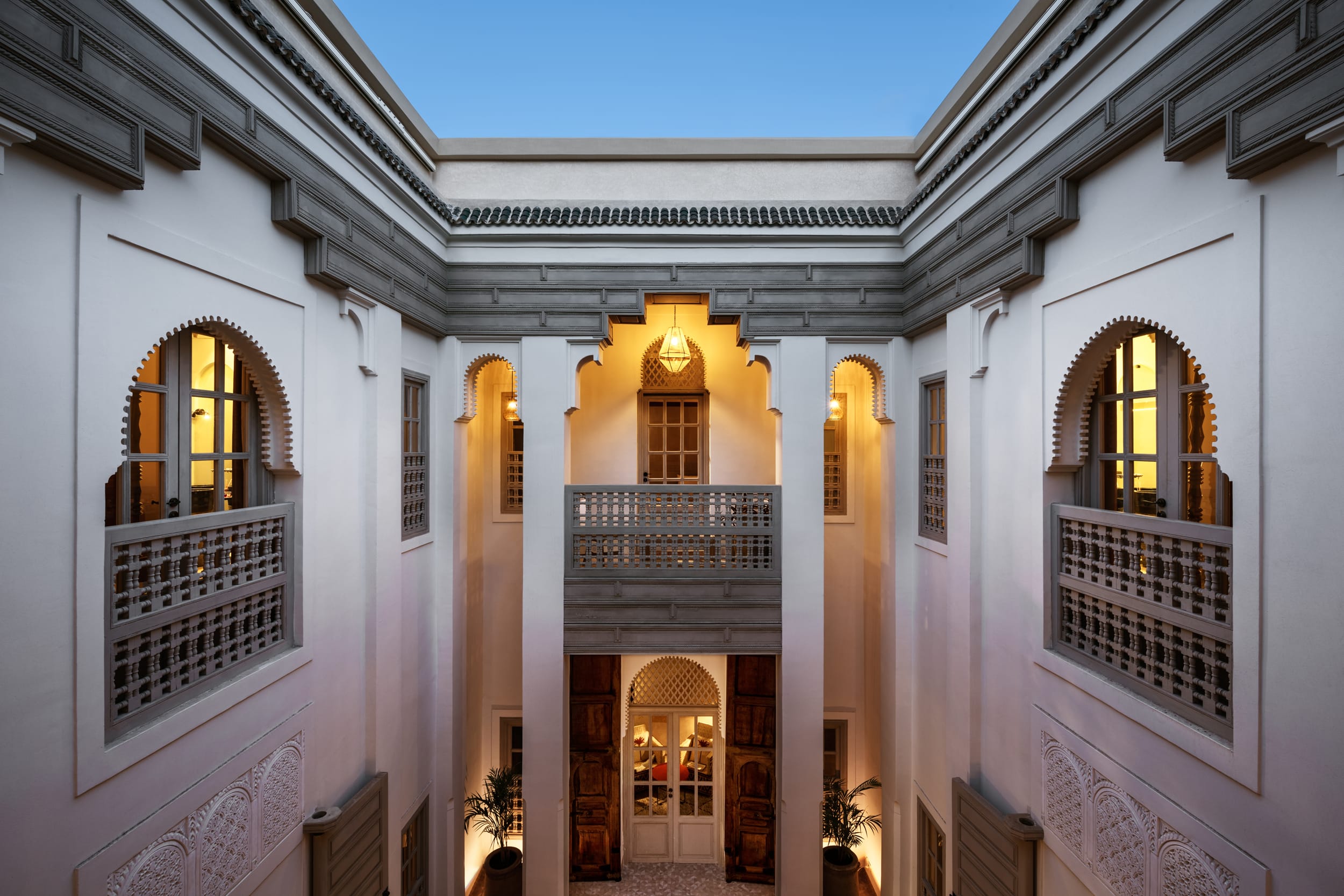 Symmetrical upper galleries around the illuminated main courtyard at 72 Marrakech
