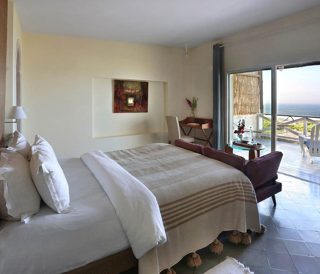 Bright guest room opening onto a private sea-facing terrace