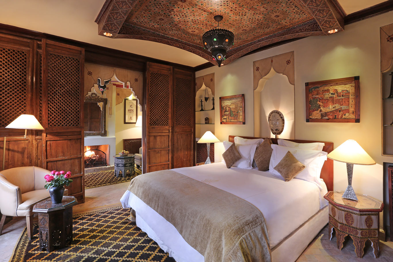 Chambre avec boiseries sculptées, cheminée et textiles marocains