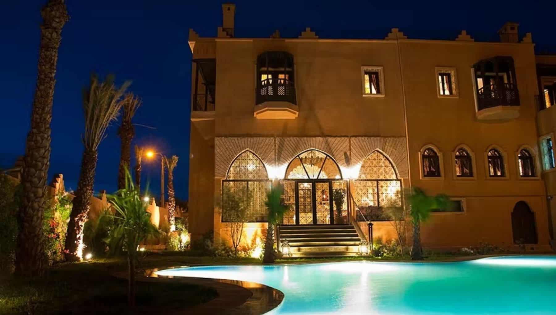 Vue nocturne de la piscine extérieure courbe et de la façade de l’hôtel