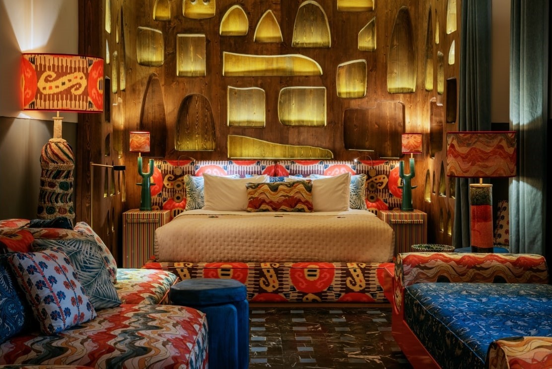 Abdel Suite with saturated textiles and a carved illuminated headboard
