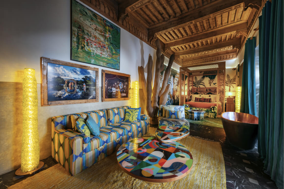 Zan Suite lounge with colourful art and a copper bath