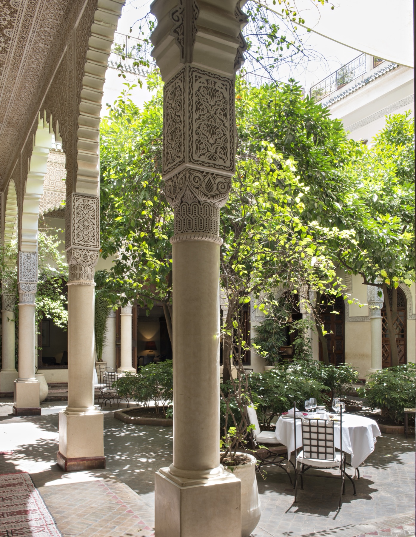 Shaded courtyard dining beneath the orange trees